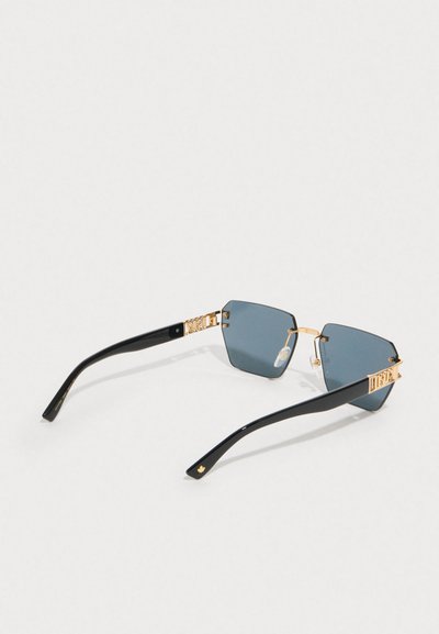 Occhiali da sole esagonali con lenti blu scuro. Montatura in plastica nera con accenti dorati e logo sulle tempie. Inclusi cuscinetti nasali trasparenti.
