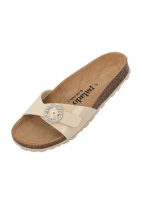 Beige slid sandaal met een glanzende band voorzien van een ronde strass gesp, tan gekussen voetbed en een gestructureerde rubberen zool.