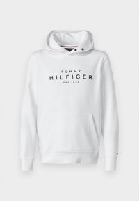 Biała bluza z kapturem z przednią kieszenią, sznurkiem do regulacji kaptura i czarnym napisem "TOMMY HILFIGER EST.1985" na piersi. Mankiety na rękawach ściągane ściągaczem.