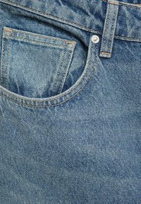 Denim tkanina u svijetloplavoj boji s teksturiranim završetkom. Ima prednju džep s metalnim gumbom i narančastim šavovima za naglašavanje.