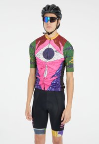 Fietsshirt met een kleurrijk abstract kunstontwerp, korte mouwen, ritssluiting aan de voorkant, gecombineerd met zwarte padded shorts met kleurrijke accenten.