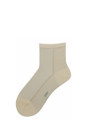 Knöchellanger beiger Socken mit verstärkter Spitze und Ferse, strukturiertem Stoff und kleinem Markenlogo in der Nähe des Ristbereichs.