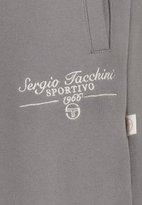 Grijze sweatshirt met witte geborduurde "Sergio Tacchini Sportivo 1966" logo en een klein zijlabel met een logo.