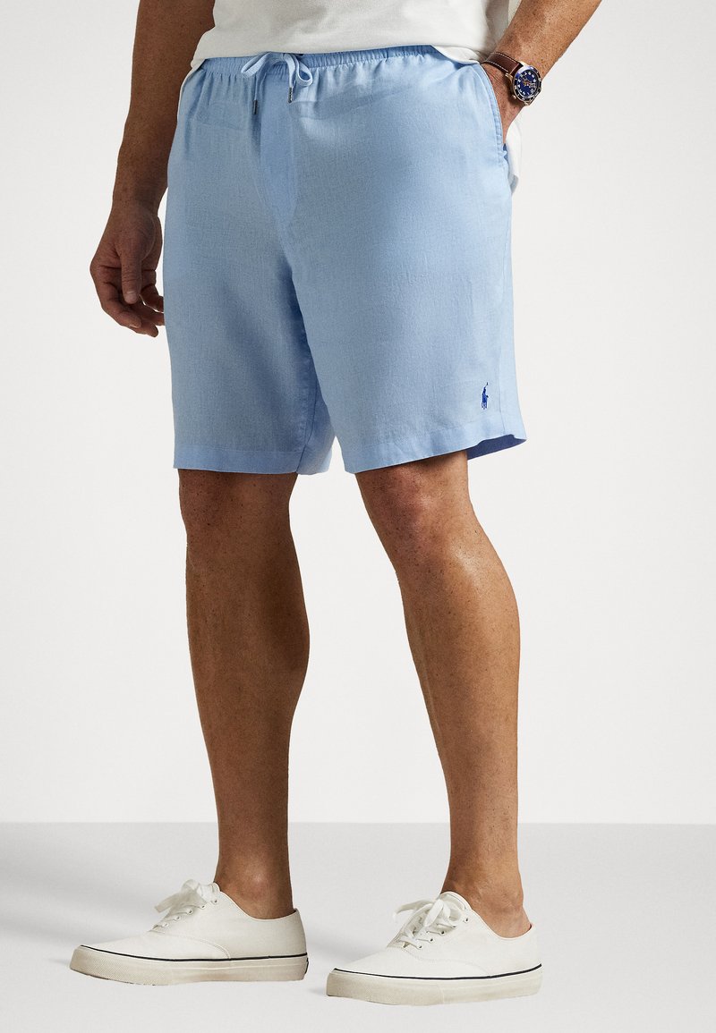 Light blue shorts made from a textured fabric with an elastic waistband and drawstring. Features a small logo on the hem.