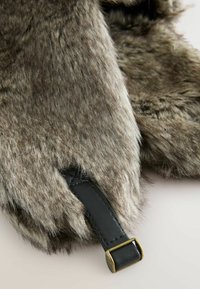 Faux fur mittens in gray with a soft, textured finish. Includes a black leather strap with a brass buckle for fastening.
