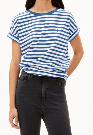 Personne portant une chemise à manches courtes rayée bleu et blanc horizontal, rentrée dans un jean noir taille haute.