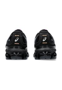 Chaussures de sport noires avec technologie GEL, tige en maille, accents violets, semelles texturées et design épuré. Présente un logo sur le talon.
