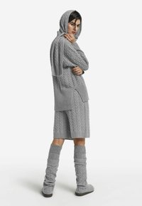 Szary dziany strój z fakturą warkocza, długimi rękawami i kapturem, zestawiony z szortami do kolan i ocieplaczami na nogi.