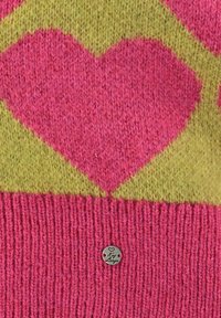 Gehaakt truien met een groot roze hartpatroon op een groene achtergrond, voorzien van een geribbelde roze zoom en een klein zilver label.