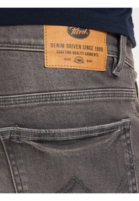 Hallide denim teksased on "Petrol" nahkapatjade ja õmblusaktsentidega. Tagakotid omavad peent disaini pehme tekstuuriga.