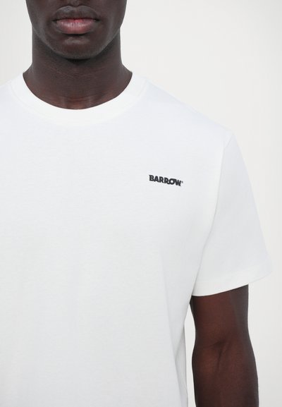 T-shirt en coton blanc avec un col rond et des manches courtes. Présente un petit logo noir "BARROW" sur la poitrine. Texture lisse.