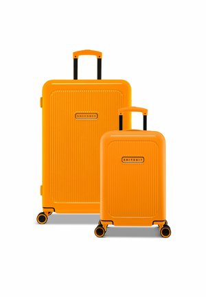 Two bright orange suitcases with vertical ribbed texture, featuring retractable handles and multi-directional wheels.