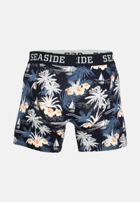 Herre boxer shorts i navy med tropisk print af palmer, blomster og sejlbåde, med en sort talje med teksten "SEASIDE".
