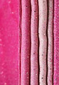 Strisce di stoffa scintillante in diverse tonalità di rosa, con una superficie testurizzata e piccoli accenti metallici, accompagnati da una finitura liscia.