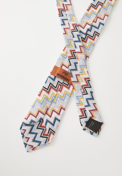 Adīta kaklasaite ar zigzaga rakstu baltā, sarkanā, dzeltenā, melnā un zilā krāsā. Iekļauts brūns marķējums un melna auduma birka.