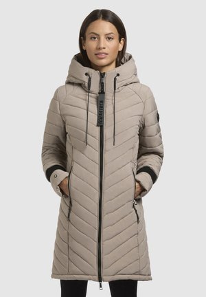 Beige gewatteerde jas met een capuchon, verticale chevron-quiltstructuur, voorkant met ritssluiting, zwarte accenten en zijzakken.