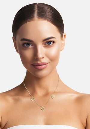 Goldfarbene Halskette mit drei herzförmigen Anhängern, ausgestattet mit einer zarten Kette, glatter Textur und einem schlichten, eleganten Design.