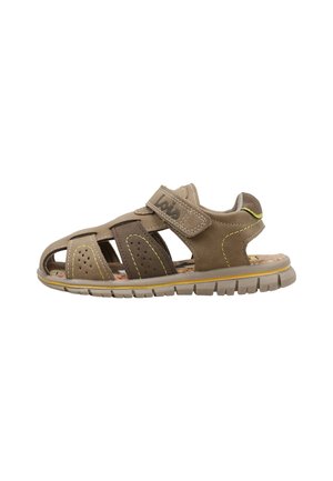 Sandalia infantil marrón y beige con punta cerrada, tira de velcro, costuras amarillas y suela flexible con dibujo.