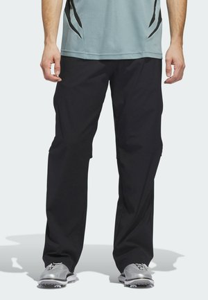 Zwarte sportbroek met een losse pasvorm, gemaakt van lichtgewicht materiaal, met subtiele accenten aan de zijkant en meshdetails bij de taille.