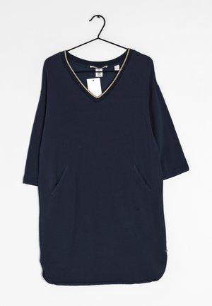 Granatowa bawełniana sukienka z dekoltem w kształcie litery V, złotym obszyciem, rękawami do łokcia i dwoma bocznymi kieszeniami. Posiada zaokrąglony dół oraz przymocowaną metkę.