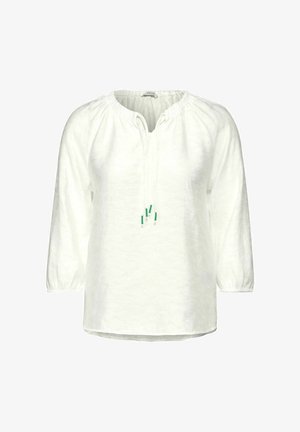 Valkoinen pellavasepäl blouse pitkillä hihoilla, rynnäkkökaula-aukossa ja säädettävissä nauhoissa vihreitä korostuksia. Hieman väljä istuvuus ja pyöristetty helma.