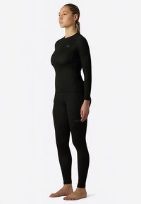 Zwart top met lange mouwen en legging gemaakt van rekbare stof. Voorzien van een subtiel logo, een nauwsluitend ontwerp en een gladde textuur.
