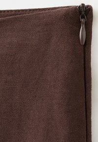 Gros plan sur une pochette en tissu brun texturé avec une fermeture éclair et une languette de tirage assorties, situées dans le coin supérieur droit.