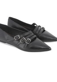 Zapatos planos de cuero negro con punteras puntiagudas, que presentan dos correas con hebillas plateadas y un diseño abierto con recortes. Textura suave, tacón bajo.