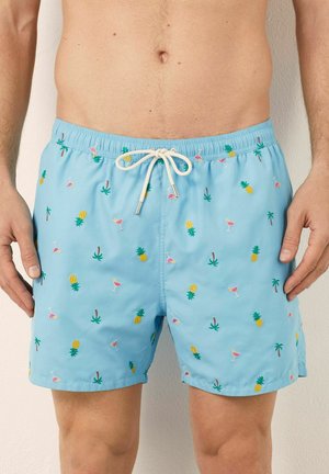 Costume de baie albastre cu talie elastică și șnur ajustabil. Prezintă un design brodat multicolor cu ananași, băuturi și palmieri.
