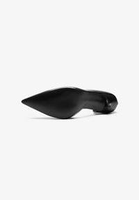 Zapato de tacón alto negro con punta afilada, textura suave y suela estriada, diseñado para una apariencia elegante y minimalista.