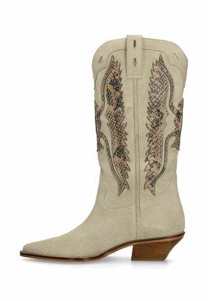 Botte de cowboy en daim beige avec bout pointu, talon en bois de hauteur moyenne et broderie ailée motif peau de serpent marron sur la tige.