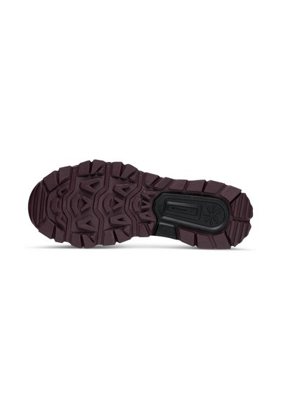 Semelle de chaussure marron foncé et robuste avec des crans profonds et un insert rectangulaire noir portant les mentions "Adhérence Tout-Terrain" et "ATG."