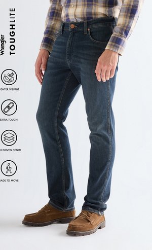 Mężczyzna w ciemnoniebieskich dżinsach, brązowych butach i koszuli w kratę, z tekstem podkreślającym cechy Wrangler ToughLite.