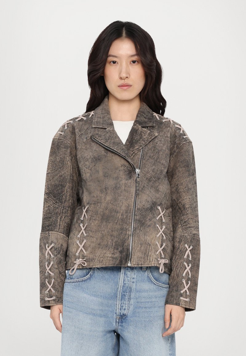 Brun läderjacka med en texturerad yta, med dragkedjestängning och snördetaljer i rosa på axlarna och ärmarna.