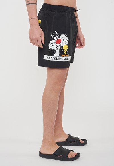 Pantaloni da bagno neri con un design a cartone animato di Silvestro e Titti. Include una cintura elastica e tasca laterale. Il testo recita "MADOV’È SILVESTRO?"