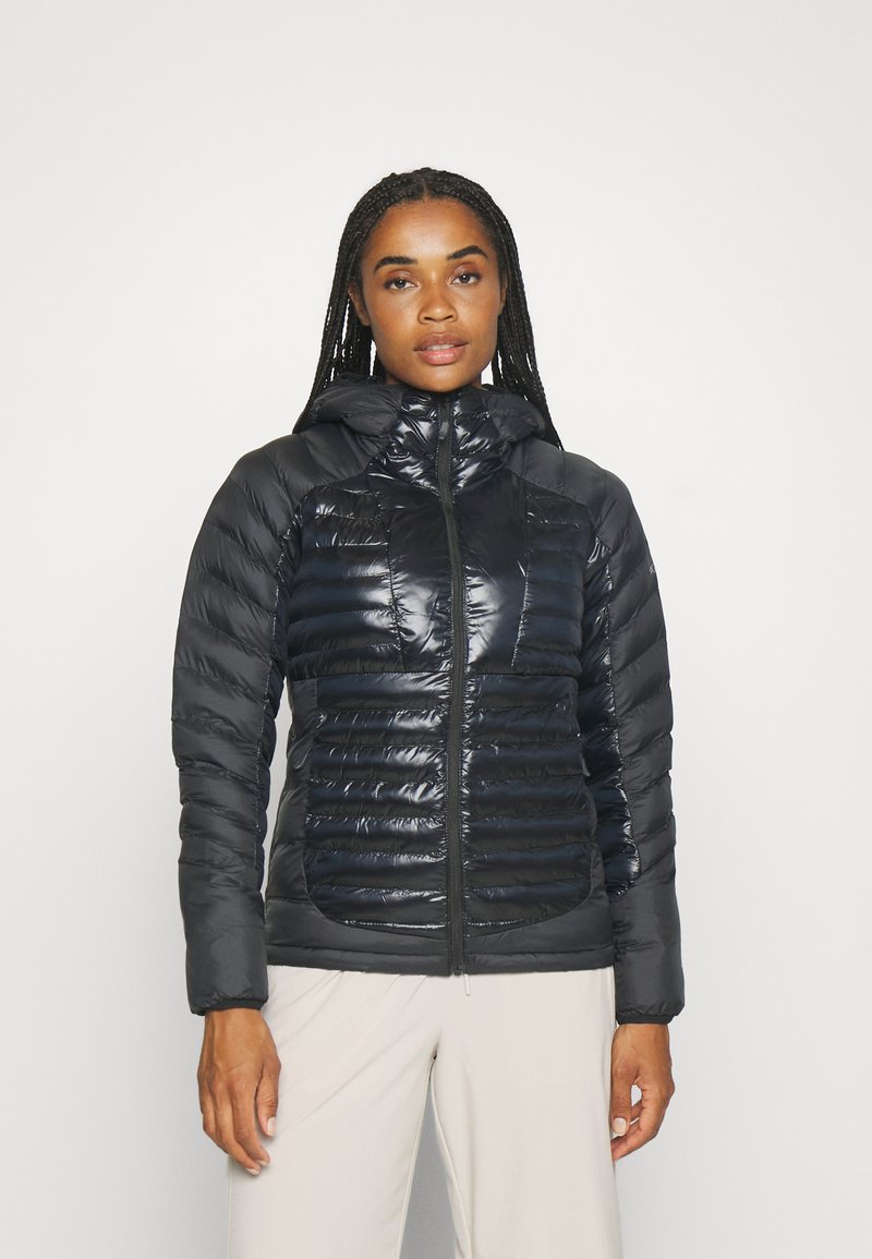 Giubbotto puffer nero con finitura lucida, texture a coste sul corpo, chiusura con zip e cappuccio. Presenta tasche sui lati.