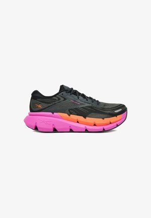 Zapatilla de correr Reebok negra y gris con suela gruesa de colores rosa brillante y naranja, cordones negros y logo naranja en el talón.