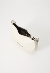 Sac à main synthétique blanc avec une texture lisse, de forme arrondie, fermeture éclair argentée et intérieur noir. Présente un logo visible sur le devant.