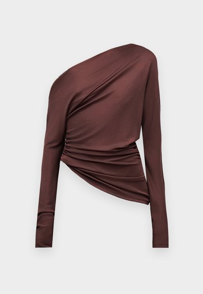 Asymetryczny, ciemnobrązowy top z długim rękawem, z jednoroźnym projektem na jedno ramię i marszczonym detalem z tkaniny na jednolitym tle.