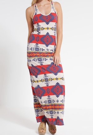 Robe maxi en tissu beige ornée de motifs géométriques rouges, bleus et jaunes. Design sans manches avec un col rond et une coupe ajustée.