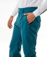 Teal skibroek met een hoge taille, twee knopen, zijzakken en ritsen bij de enkels. Gemaakt van waterafstotend materiaal met een zachte textuur.