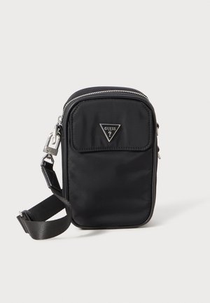 Schwarze Nylon-Schultertasche mit einem dreieckigen Metall-Logo, Reißverschlusstaschen und einem verstellbaren Tragegurt. Glatte Textur und minimalistisches Design.
