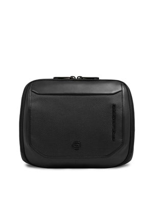 Bolsa compacta negra con cremallera, panel frontal texturizado, bordes lisos y logo sutil grabado y estampado verticalmente en el lateral.