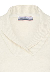 Maglione lavorato a maglia di colore crema con colletto a coste ripiegato. Presenta un'etichetta con "FELIX HARDY" ricamata in blu e rosso. Texture morbida, leggero.