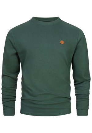 Pull à côtes vert foncé à manches longues avec col rond et petite étiquette ronde en cuir marron avec logo sur la poitrine gauche.