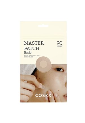 Persona che applica un piccolo cerotto rotondo per l'acne sulla guancia; confezione del prodotto per la cura della pelle etichettata "Master Patch Basic" con 90 cerotti mostrati.