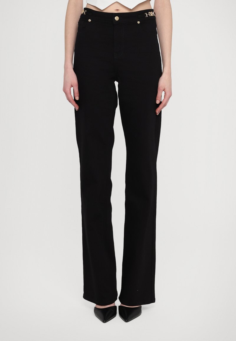 Black denim high-waisted jeans with straight leg fit, gold hardware accents, and four pockets. Smooth texture with minimal stitching detail.