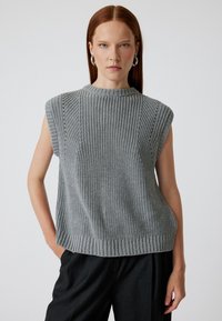 Top senza maniche grigio in maglia, con colletto alto, tessuto testurizzato e orlo a coste, caratterizzato da spalle leggermente definite e dettagli in lavorazione aperta.