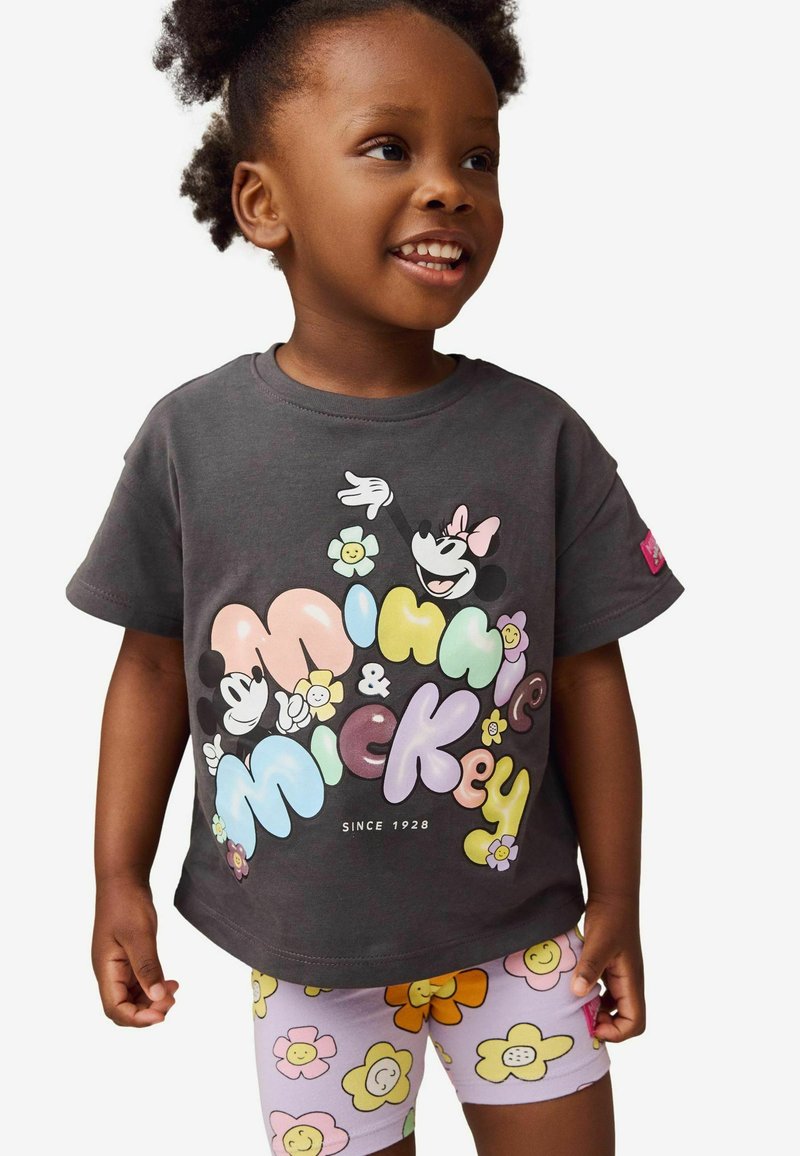 Czarny t-shirt z kolorowymi grafikami Myszki Mickey i Minnie w otoczeniu kwiatów, w zestawie z jasnofioletowymi szortami ozdobionymi wzorami kwiatowymi.