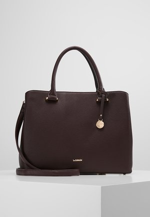 Bolso de cuero marrón oscuro con textura, con doble asa, correa de hombro desmontable y un adorno redondo de tono dorado en el frente.